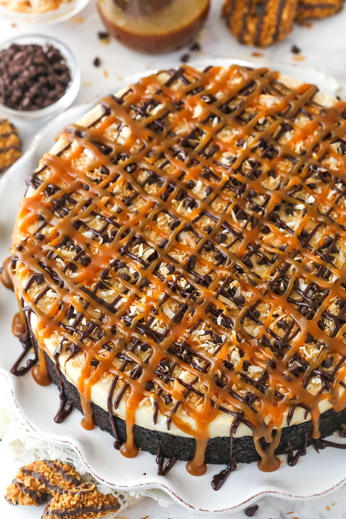 Cure your Girl Scout cookie cravings with this Samoa cheesecake! It's a no-bake cheesecake chock-full of caramel, chocolate, and coconut. Overhead image of Samoa cheesecake on a serving platter.