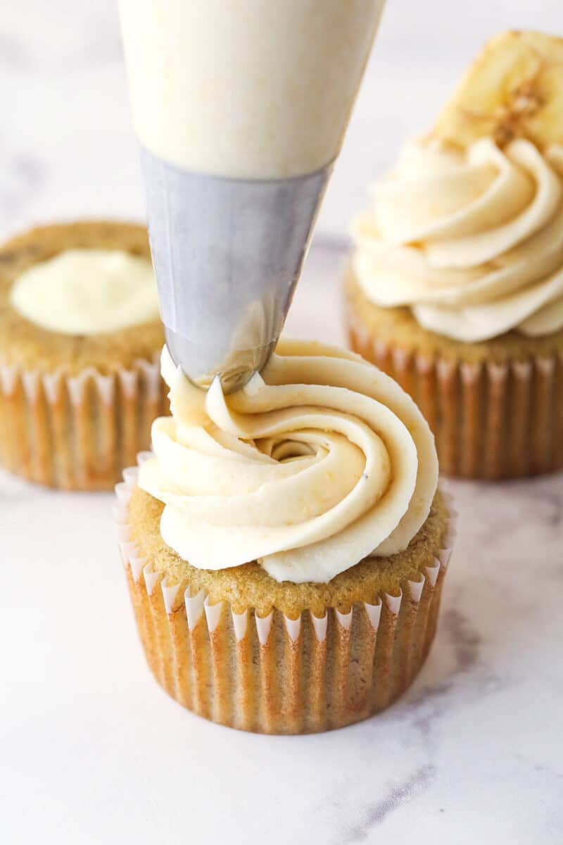 Piping banana frosting onto banana cream pie cupcakes.