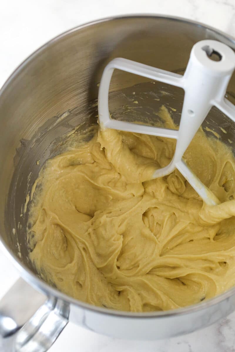 Mixing eggs and vanilla into cupcake batter.
