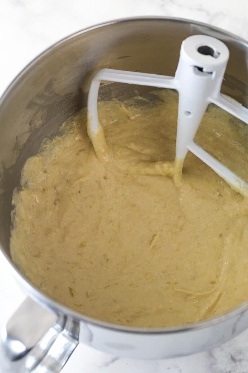 Adding dry ingredients and mashed bananas to cupcake batter.