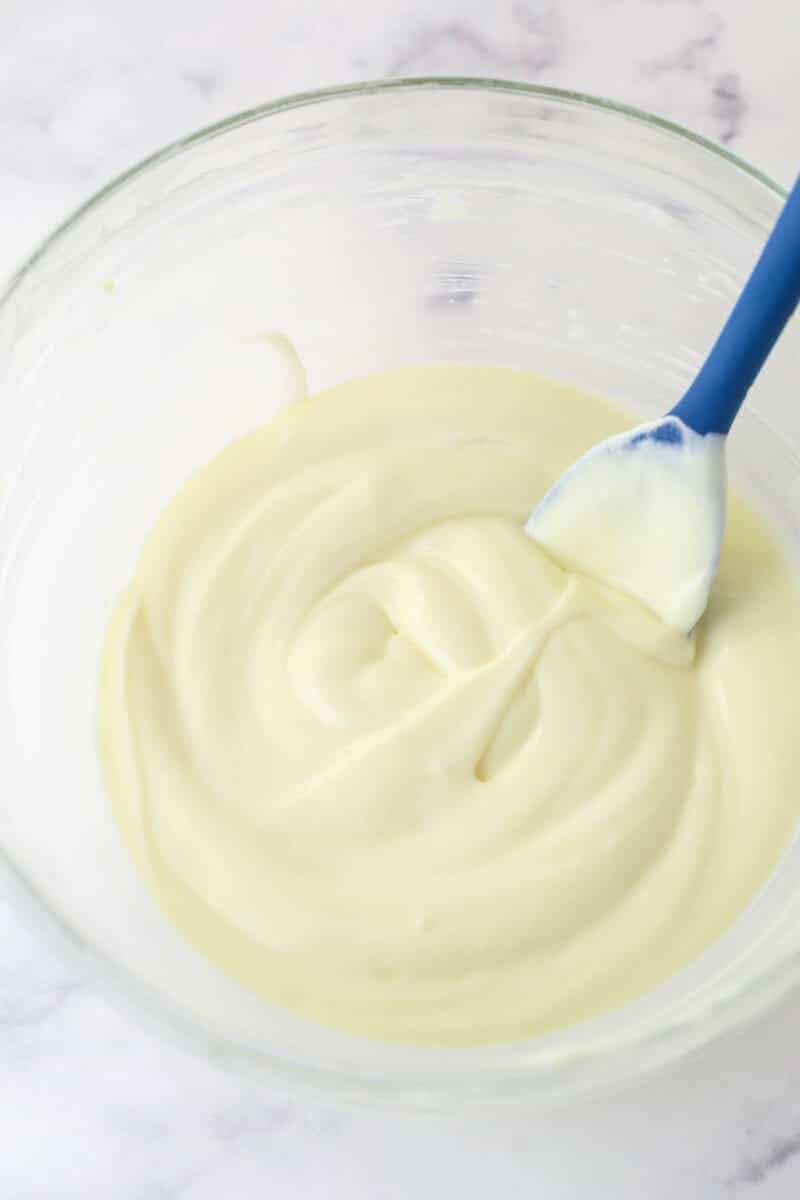 Folding whipped cream into custard filling for banana cream pie cupcakes.