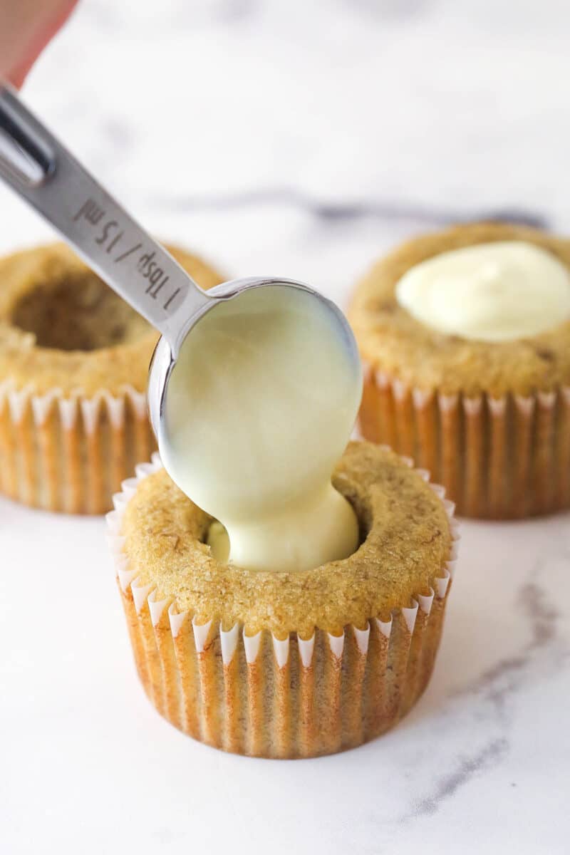 Filling banana cupcakes with custard.