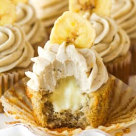A banana cream pie cupcake with a bite taken out of it.