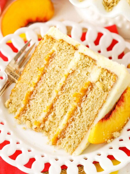 A slice of Brown Sugar Layer Cake With Peach Filling next to a silver fork on a white plate