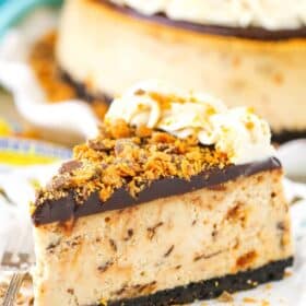 A slice of Butterfinger Cheesecake on a white plate