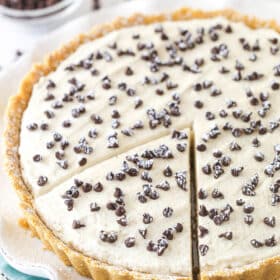 Cannoli tart on a serving platter with a slice cut and ready to serve.