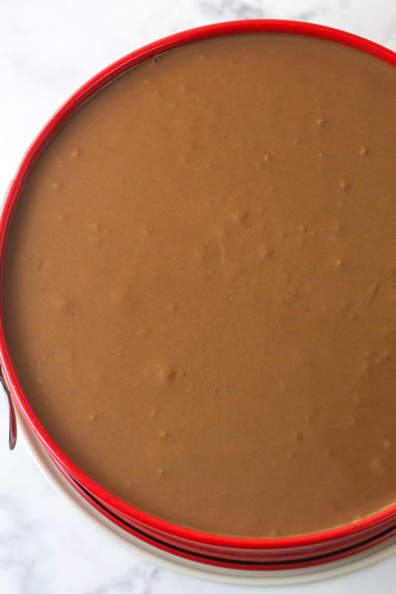 This German Chocolate Cheesecake with layers of creamy German chocolate cheesecake and gooey coconut pecan topping is out of this world! Spreading a layer of German chocolate cheesecake filling over a layer of coconut pecan topping,