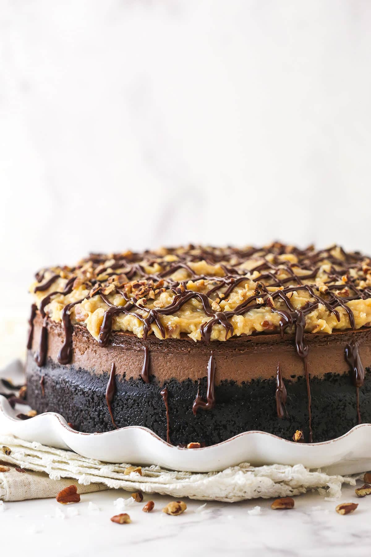 This German Chocolate Cheesecake with layers of creamy German chocolate cheesecake and gooey coconut pecan topping is out of this world! German chocolate cheesecake on a serving platter.