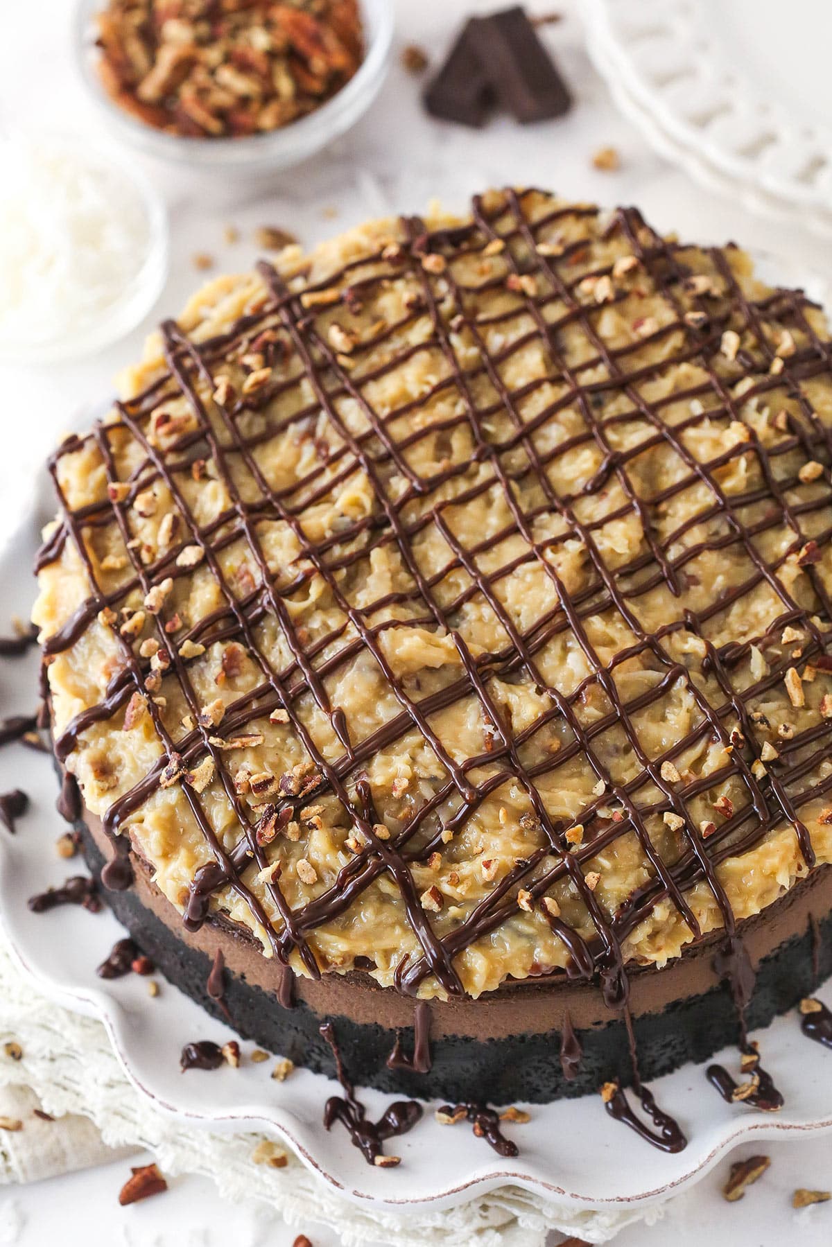 This German Chocolate Cheesecake with layers of creamy German chocolate cheesecake and gooey coconut pecan topping is out of this world! Overhead image of German chocolate cheesecake on a serving platter.