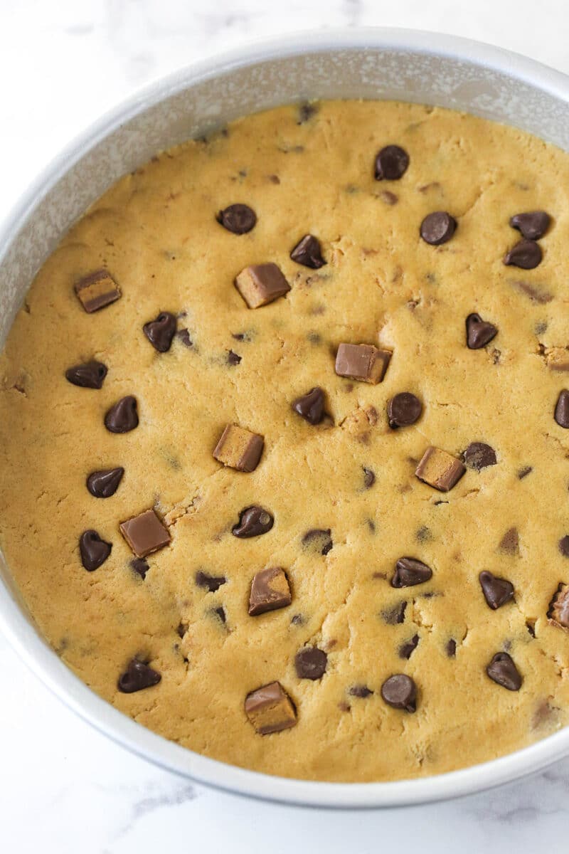 Reese's peanut butter cookie cake dough pressed into a cake pan.