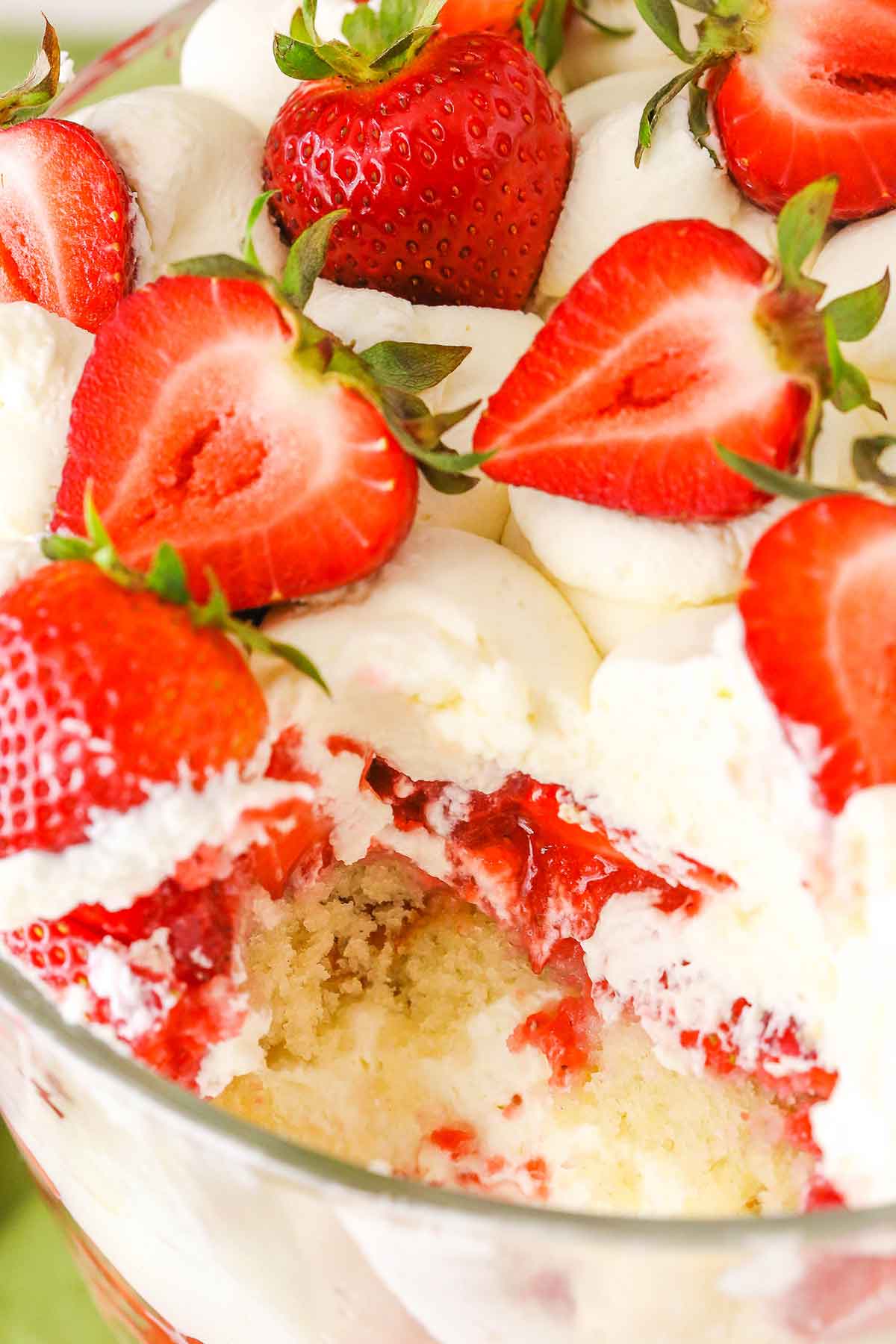 Overhead view of a Strawberry Shortcake Trifle with a serving removed in a glass trifle dish