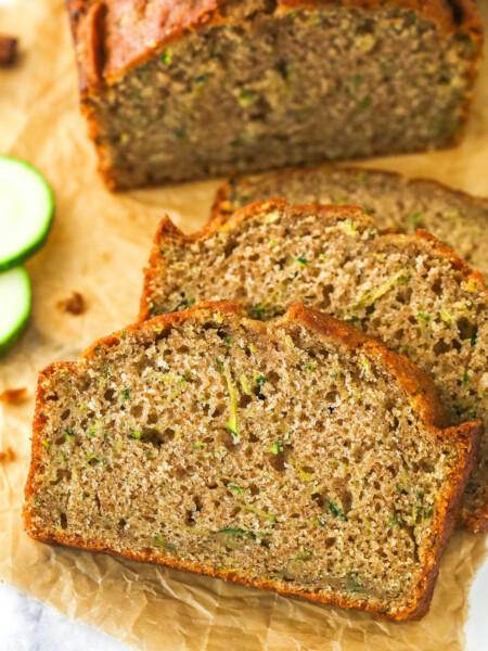 Overhead image of zucchini bread cut into slices on a cutting board.