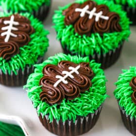 football cupcakes on white ruffle platter