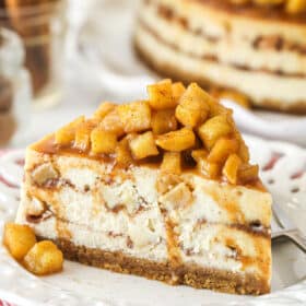 A slice of Apple Cinnamon Cheesecake piled high with apple topping.
