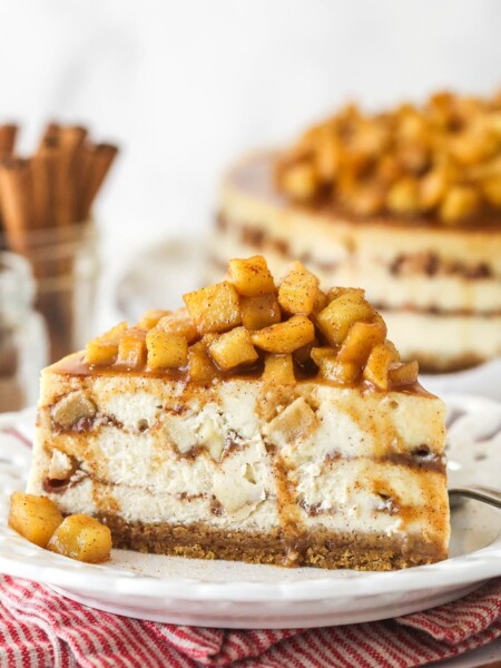 Side view of a slice of Apple Cinnamon Cheesecake on a small white plate.