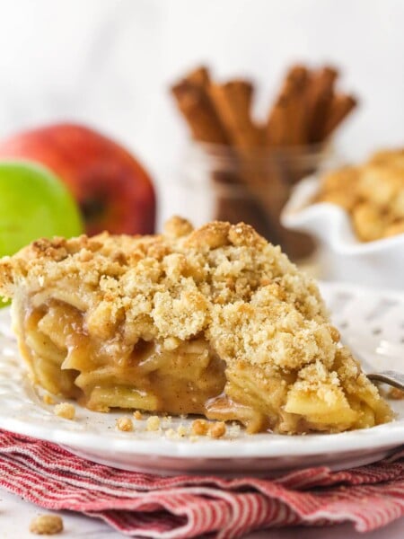 A slice of dutch apple pie on a white plate