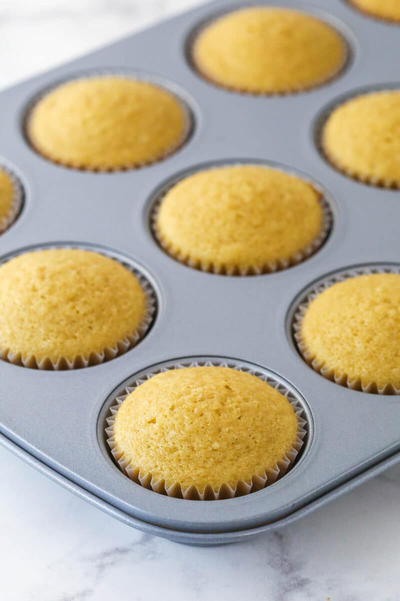 A cupcake pan with baked cupcakes in it.