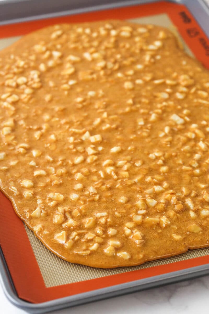 A baking sheet with a slab of macadamia brittle on it.