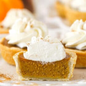 Front view of a mini pumpkin pie cut in half to see the pumpkin filling