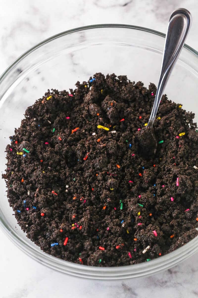 A mixing bowl with chocolate sprinkle crust mixture.