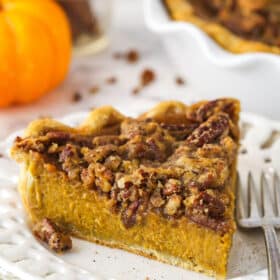 A slice of pecan praline pumpkin pie on a white plate