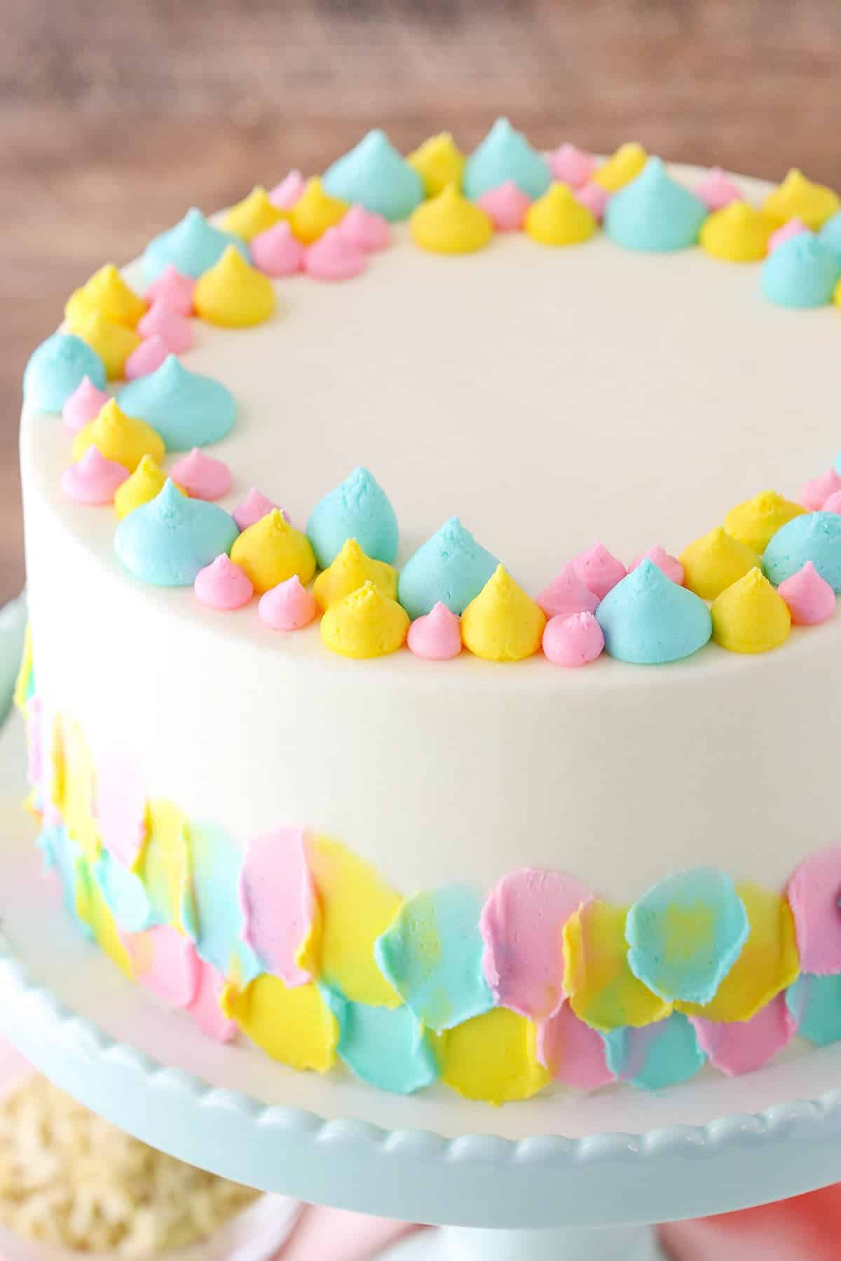 This Almond Custard Layer Cake is made with moist almond cake layers, a smooth almond custard and classic almond frosting! The flavor is light and lovely and I'm a big fan! A full Almond Custard Layer Cake on a light blue cake stand
