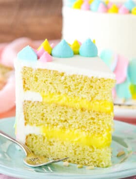 A slice of Almond Custard Layer Cake next to a fork on a light blue plate