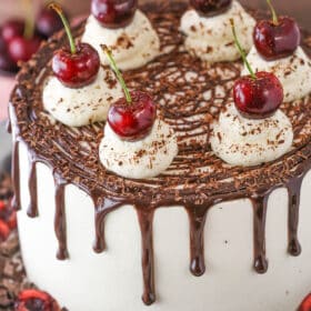 A full black forest cake on a cake stand.
