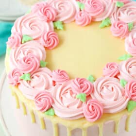 Overhead view of a full Carvel Cake with pink swirls on a white cake stand