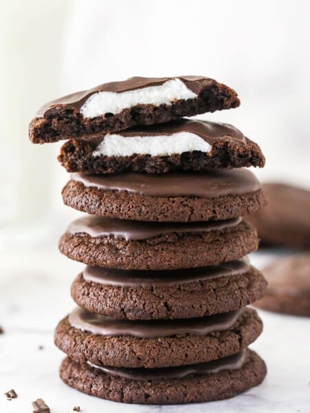 A stack of chocolate marshmallow cookies, with one cut in top on half to show the marshmallow inside