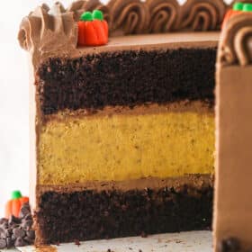A Chocolate Pumpkin Cheesecake Cake with slices removed to show interior layers.