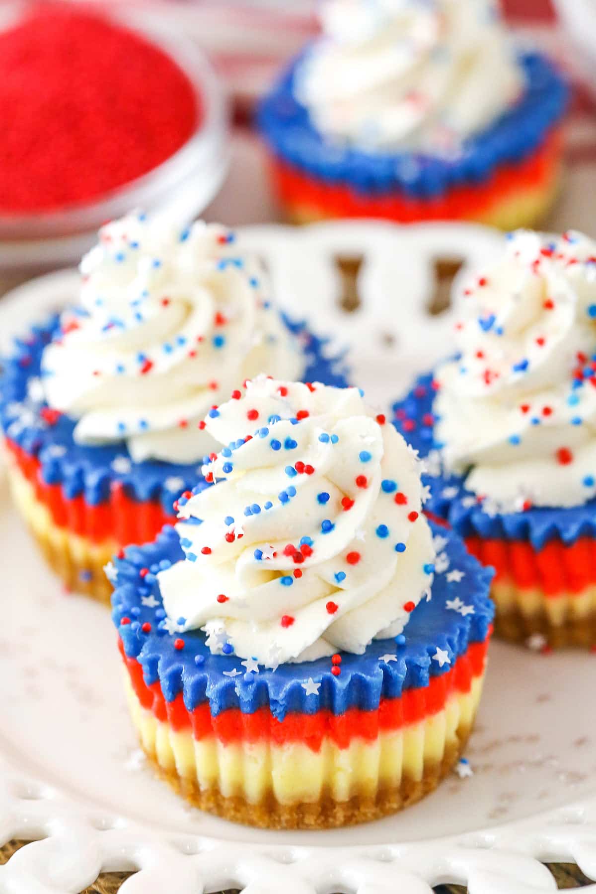 These Red, White and Blue Mini Cheesecakes are smooth, creamy and easy to make! Perfect for your patriotic celebration! Red White and Blue Mini Cheesecakes on a white plate