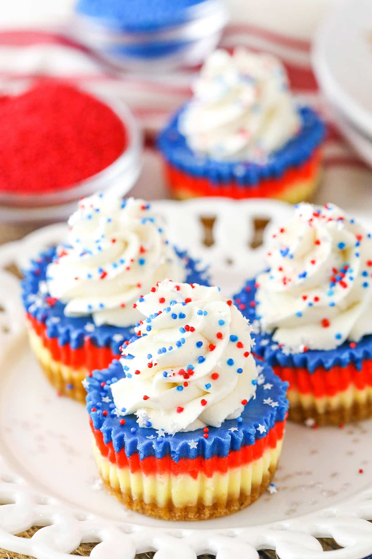 These Red, White and Blue Mini Cheesecakes are smooth, creamy and easy to make! Perfect for your patriotic celebration! Red White and Blue Mini Cheesecakes on a white plate