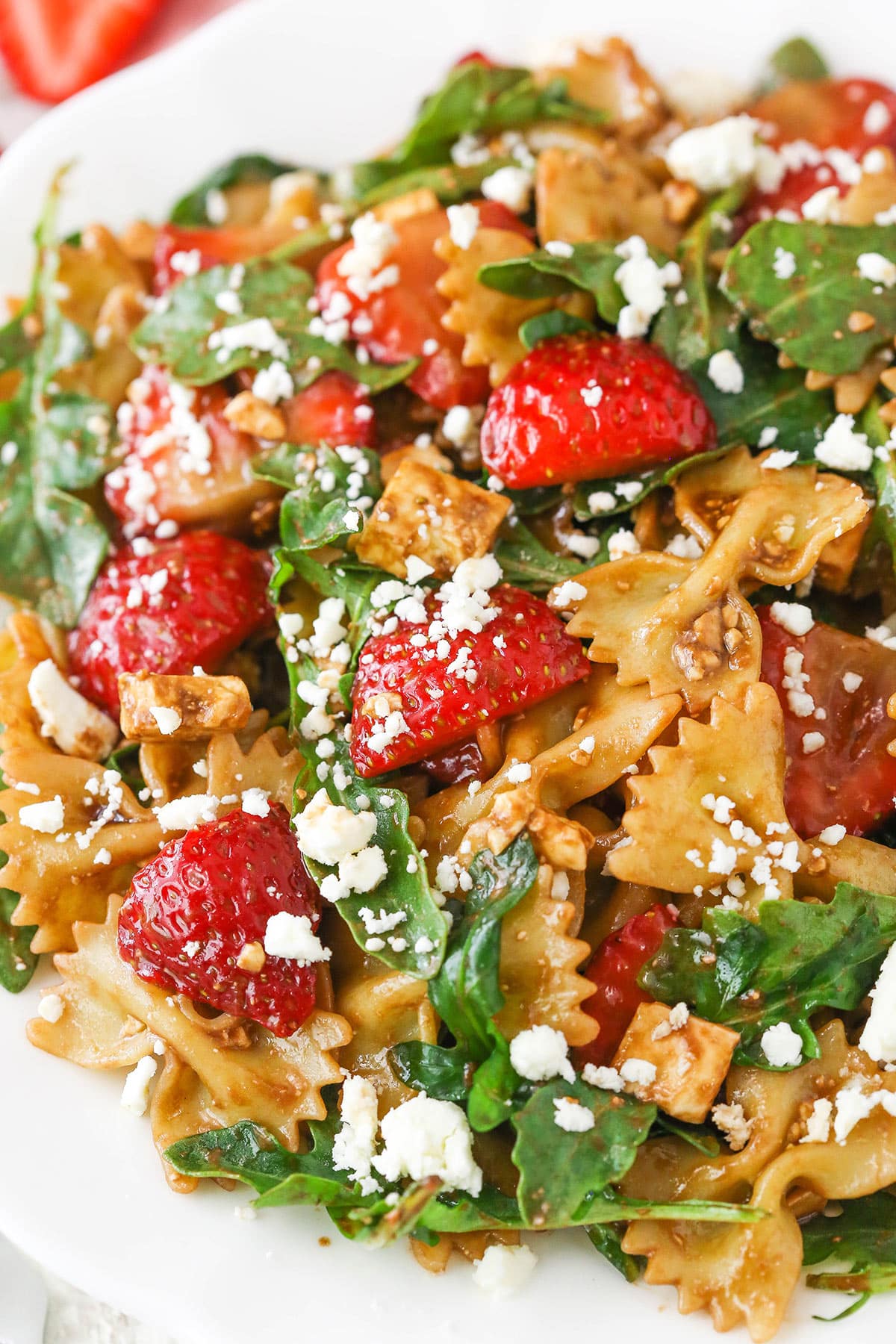 This Strawberry Feta Balsamic Pasta Salad is easy to make, fresh and delicious for summer! It's so many of my favorite things in one! Strawberry Feta Balsamic Pasta Salad on a white plate