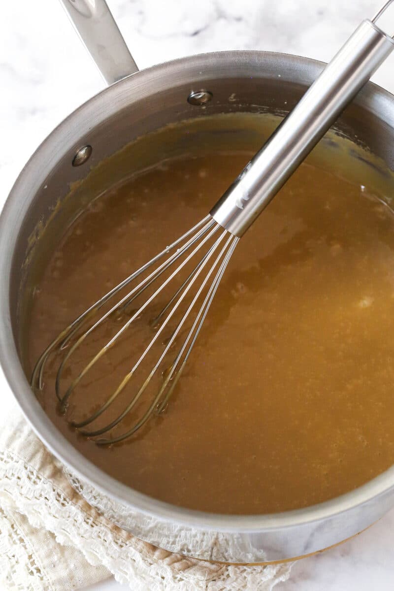 Banoffee Pie is an irresistible dessert made with a graham cracker crust, toffee filling, banana slices, and whipped cream. Whisking toffee in a pot