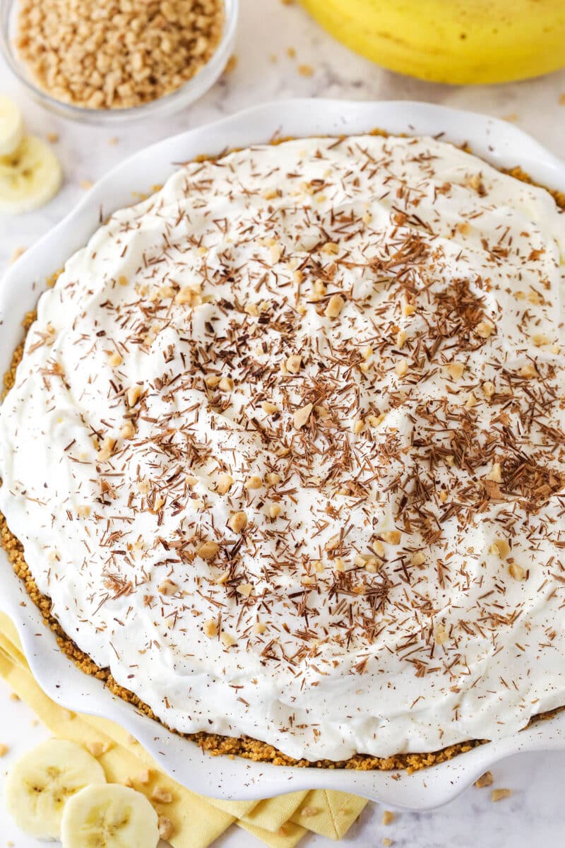 Banoffee Pie is an irresistible dessert made with a graham cracker crust, toffee filling, banana slices, and whipped cream. Overhead view of a banoffee pie