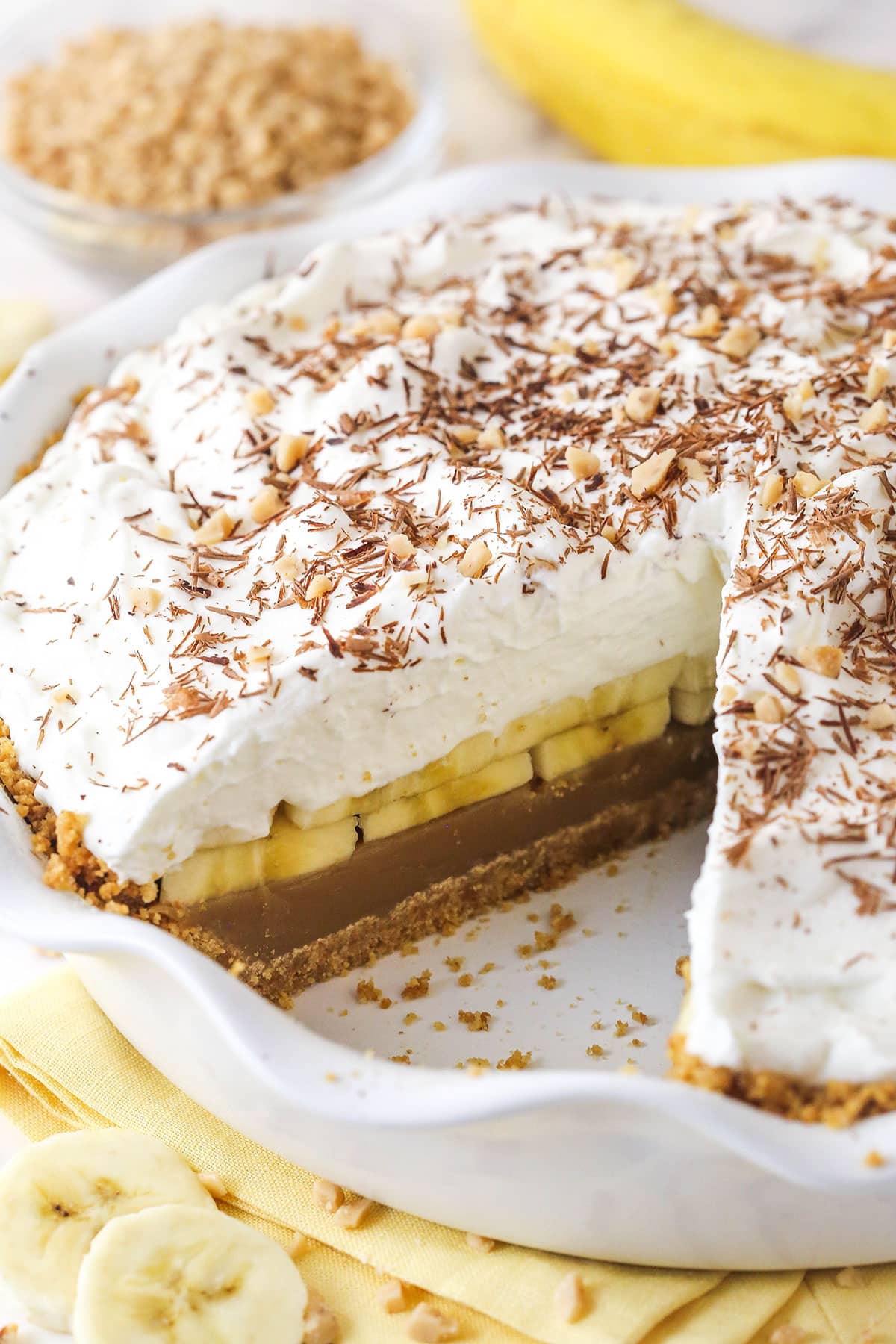 Banoffee Pie is an irresistible dessert made with a graham cracker crust, toffee filling, banana slices, and whipped cream. A banoffee pie with a slice missing
