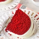 Overhead view of a slice of red velvet bndt cake on a white plate