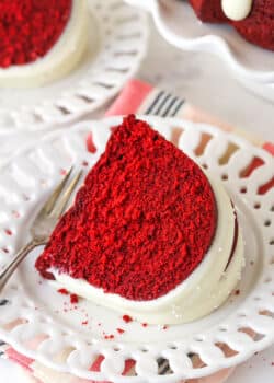 Overhead view of a slice of red velvet bndt cake on a white plate