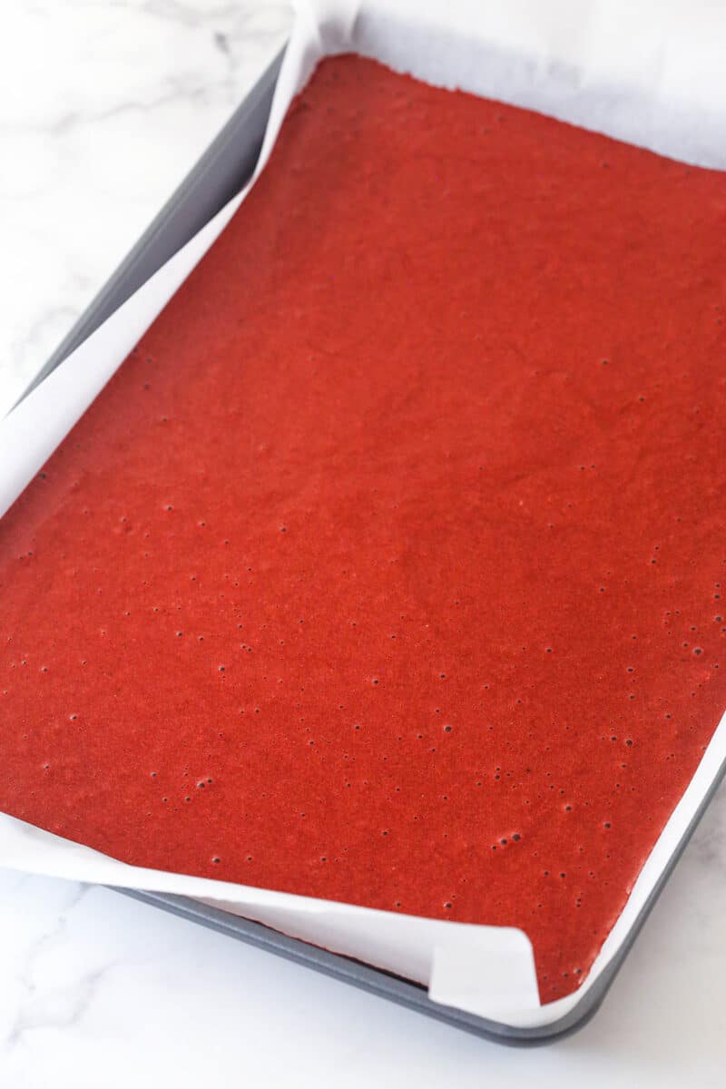 This red velvet cake roll is light and tender with the signature tang and hint of chocolate flavor. Perfect for Christmas & Valentine's Day! Red velvet cake in a jelly roll pan