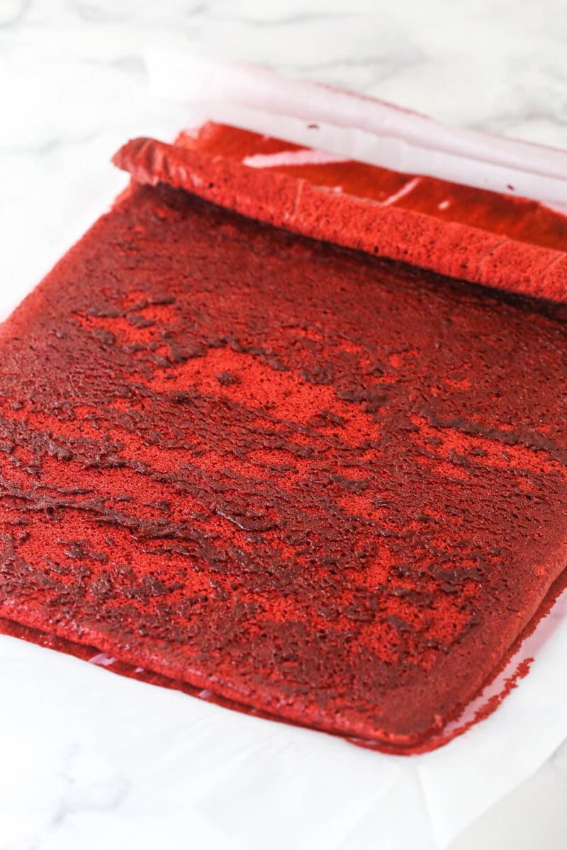 This red velvet cake roll is light and tender with the signature tang and hint of chocolate flavor. Perfect for Christmas & Valentine's Day! Unrolling a red velvet cake
