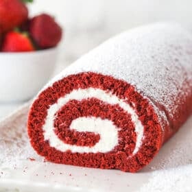 Front view of red velvet cake roll on a white platter