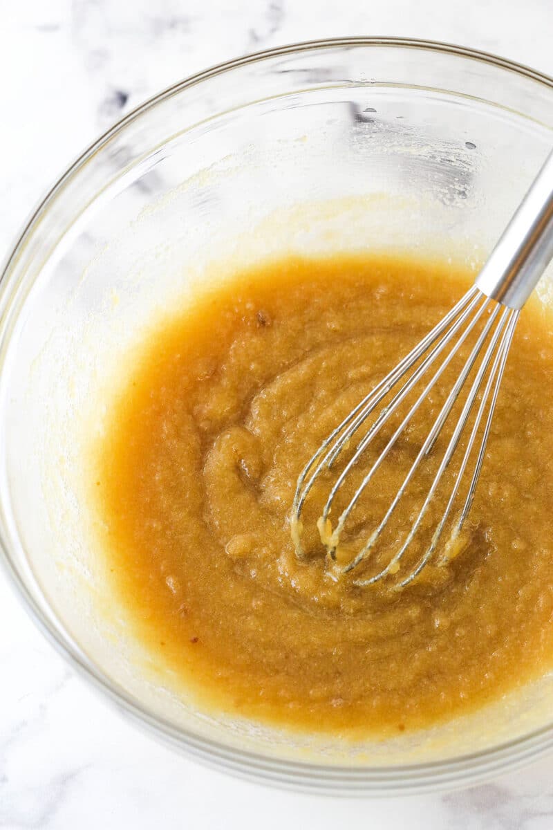 Whisking together melted butter and brown sugar.