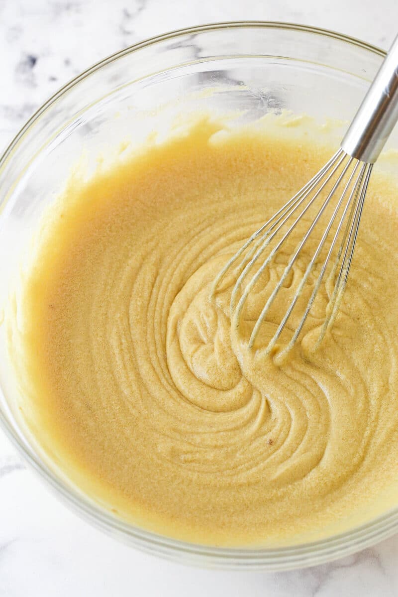 Whising eggs and vanilla into a cooled mixture of melted butter and brown sugar.