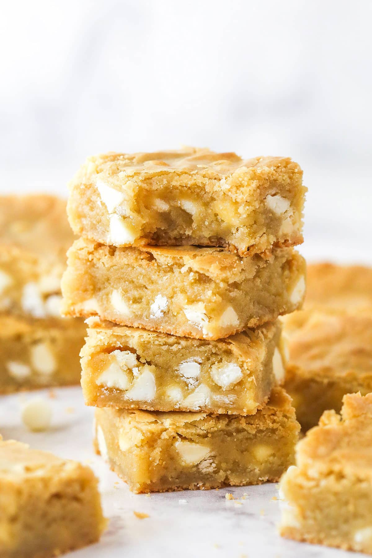 A stack of blondies. The top one has a bite taken out of it.
