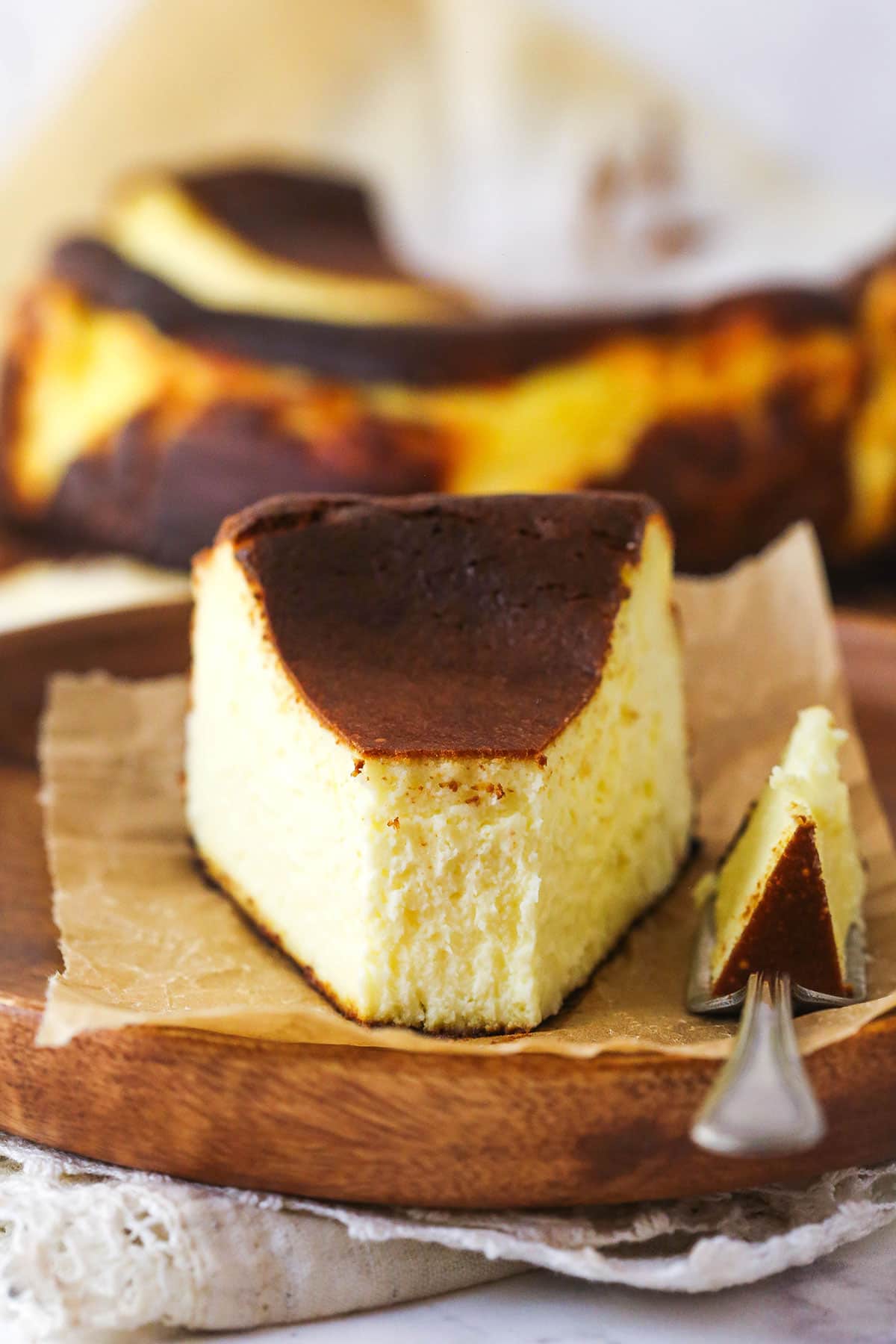 A slice of burnt basque cheesecake with a bite taken out of it.