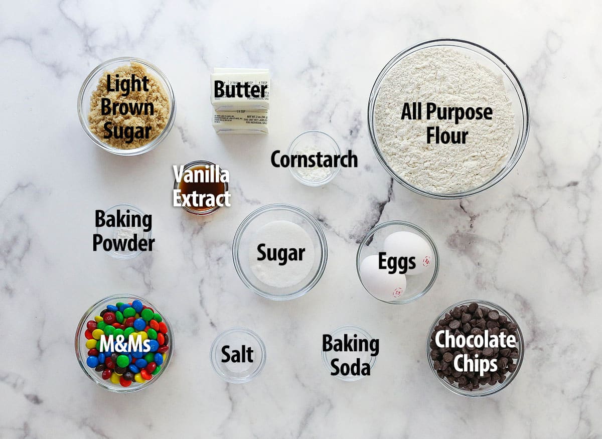 Ingredients for soft baked M&M cookie recipe spread out on a counter.