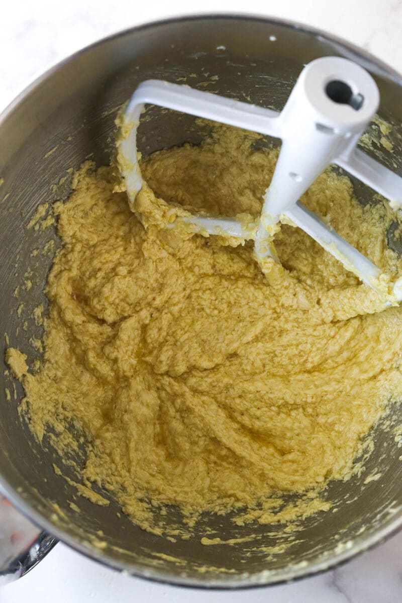 Mixing the eggs and vanilla into cookie dough.