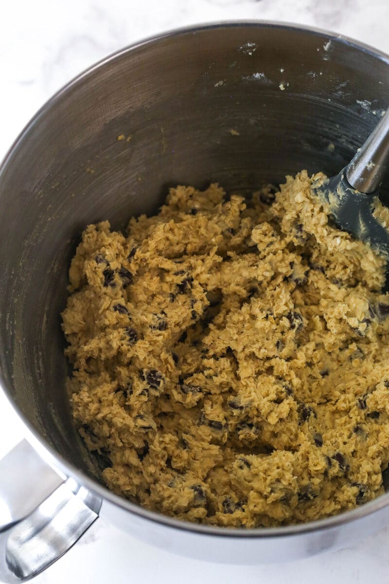 Folding oatmeal and chocolate chips into cookie dough.