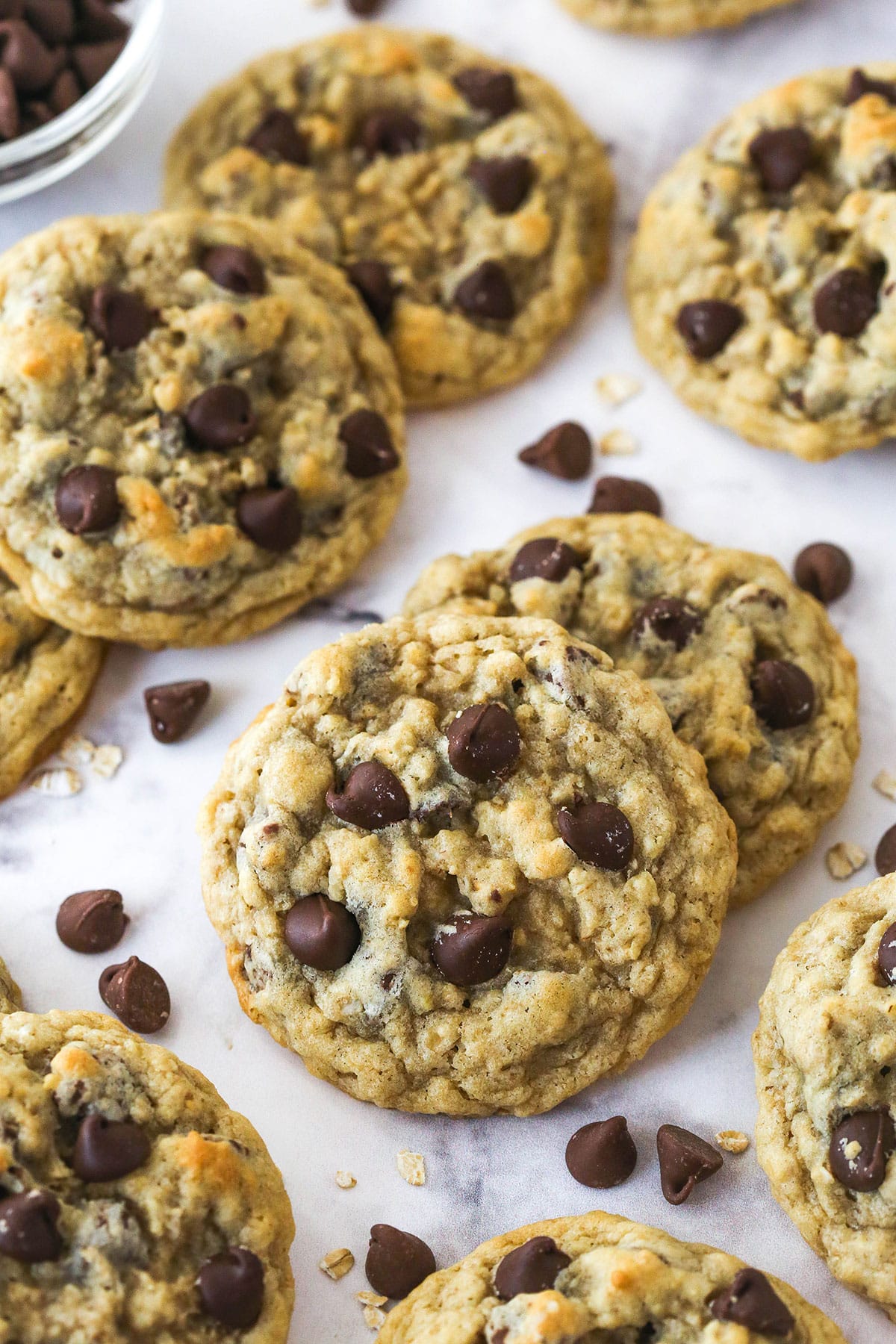 Oatmeal chocolate chip cookies spread out on a counter top.